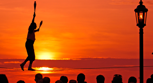 Will Soto juggles while balancing on the tightrope at the Mallory Square sunset celebration. Photo: Bob Krist/Florida Keys News Bureau 